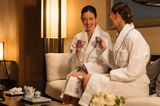 Two women enjoying tea in a relaxing spa lounge at DLUX Health & Beauty Centre