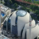 Aerial view of a modern mosque with a dome and minarets