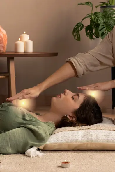 reiki-healing-session-wellness-relaxation Therapist performing a reiki energy healing session on a relaxed woman lying on a mat in a peaceful spa environment